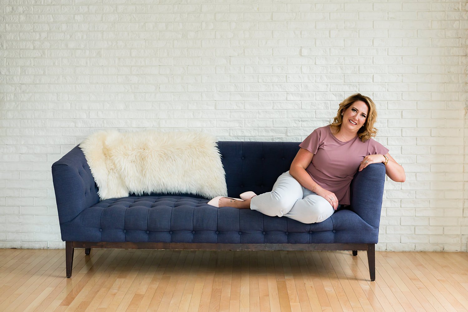 professional woman sitting on blue couch